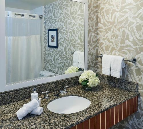 bagno con lavandino e grande specchio di Argonaut Hotel, a Noble House Hotel a San Francisco