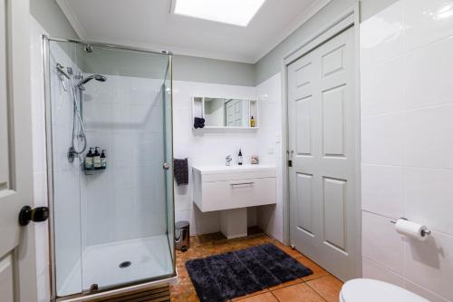 ein Bad mit einer Dusche und einem Waschbecken in der Unterkunft Bundara - Idyllic Getaway in the Mountains in Mount Tamborine