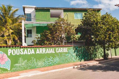 um edifício com um sinal que diz pussada cuidados com animais em Pousada Arraial Caribe em Arraial do Cabo