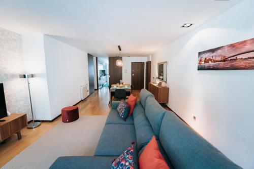a living room with a blue couch in a room at Refugio do Gerês-Apartamento in Geres