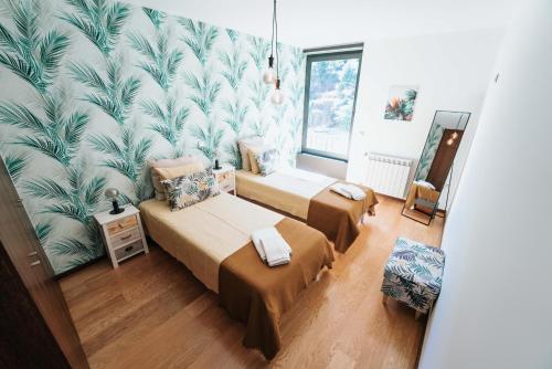 a bedroom with two beds and a wall mural at Refugio do Gerês-Apartamento in Geres