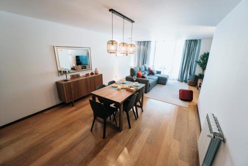 a living room with a dining table and a living room with a couch at Refugio do Gerês-Apartamento in Geres