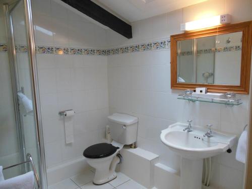 a white bathroom with a toilet and a sink at Highfield Farm in Sandy