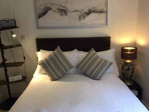 una camera con un letto bianco con due cuscini di Holyrood Park Apartment a Edimburgo