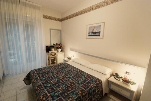 ディアーノ・マリーナにあるHotel Residence Mediterraneoのベッドと窓が備わるホテルルーム