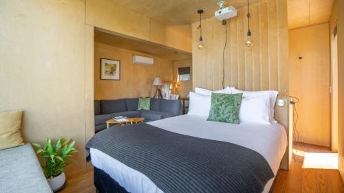 um quarto com uma cama grande e um sofá em EcoScapes em Glenorchy