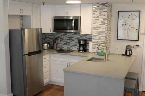 a kitchen with a stainless steel refrigerator and a sink at 18-Universal and Heart of International Dr in Orlando