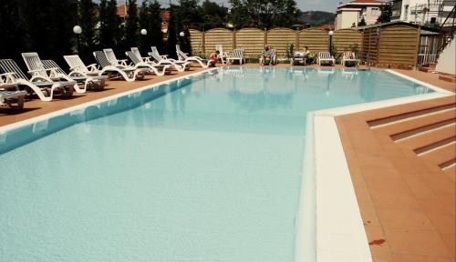 ein großer Pool mit Liegestühlen in einem Hotel in der Unterkunft Hotel Residence Mediterraneo in Diano Marina
