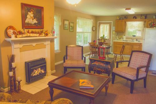 sala de estar con chimenea, mesa y sillas en Nolichuckey Bluffs Bed & Breakfast Cabins, en Greeneville