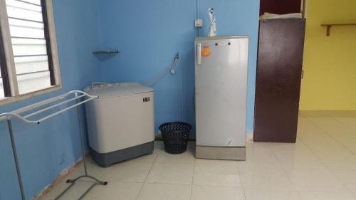 a bathroom with a blue wall and a small refrigerator at SRHOMESTAY KUALA TERENGGANU in Kuala Terengganu