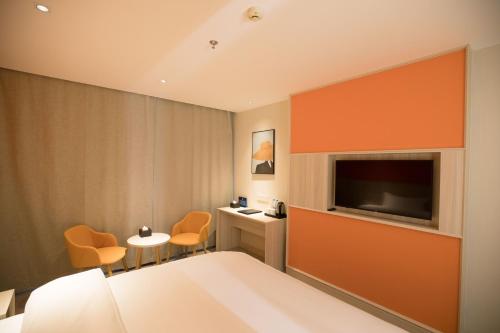 a hotel room with a bed and a flat screen tv at Beijing Saga Hotel in Beijing