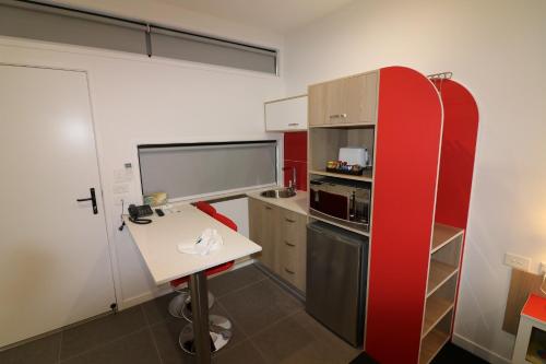 a kitchen with a sink, stove, and refrigerator at Room Motels Kingaroy in Kingaroy