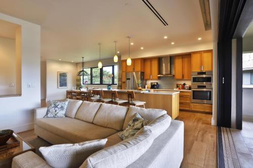 a living room with a couch and a kitchen at Honua kai - Luana Garden Villa 3C in Kaanapali