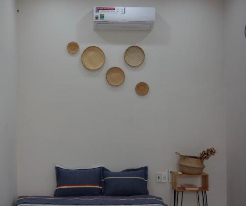 a living room with a couch and a wall with a fan at Kontum Home Sweet Homestay in Kon Tum
