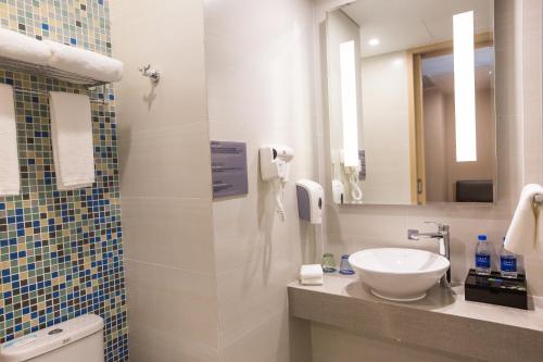 a bathroom with a sink and a mirror at Holiday Inn Express Emei Mountain by IHG in Emeishan