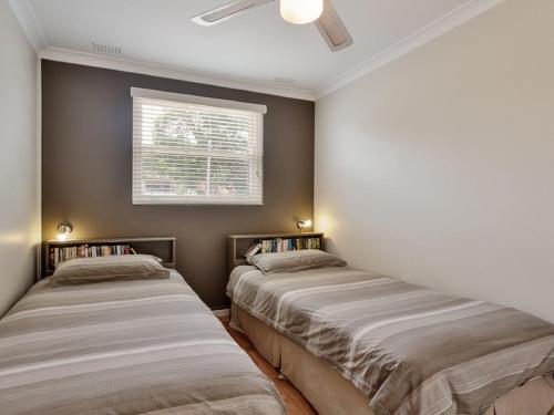two beds in a room with a window at Sebastapol, 4,66 Thurlow Avenue - Unit with wonderful views across the bay in Nelson Bay