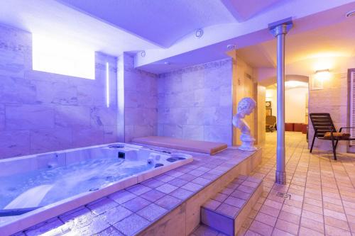 a large bathroom with a tub with a statue in it at Active & Wellness Hotel Subterra in Ostrov