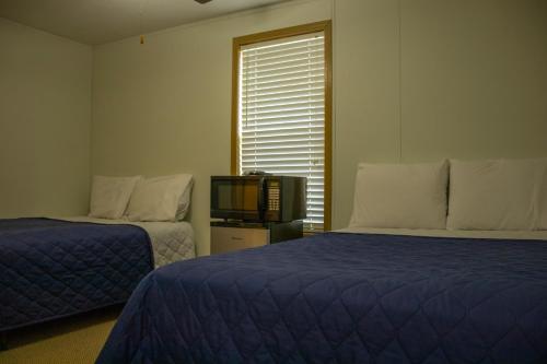 a room with two beds and a tv and a window at Tumbleweed Lodge - No Smoking, No Pets in Monahans