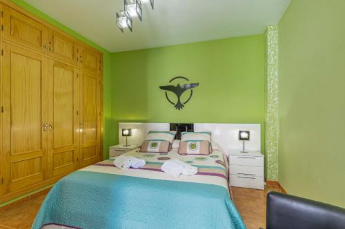 ネルハにあるApartamento Steffi - Centro de Nerjaの緑の壁、ベッド付きのベッドルーム1室