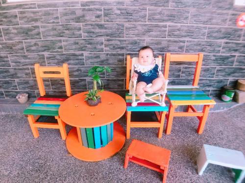 a baby sitting in a chair inront of four chairs at Dai B&B in Jincheng