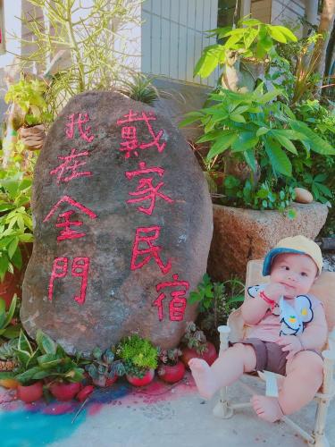a baby sitting in a chair in front of a rock at Dai B&B in Jincheng