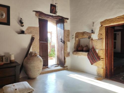 Zimmer mit einem Fenster und einer Vase auf dem Boden in der Unterkunft Bendeni Cottage in Megála Khoráfia