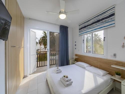 ein Schlafzimmer mit einem großen weißen Bett und einem Fenster in der Unterkunft Passion Villa in Protaras