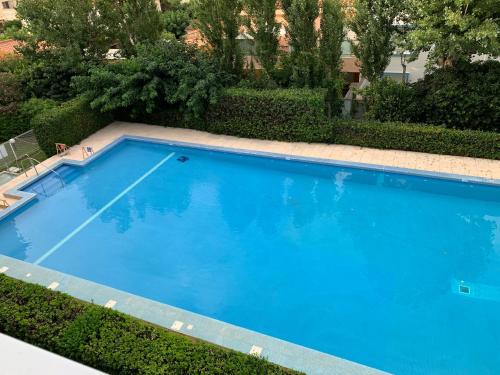 une grande piscine bleue dans une cour dans l'établissement Canet Plage Appartement Cosy très calme, à Canet