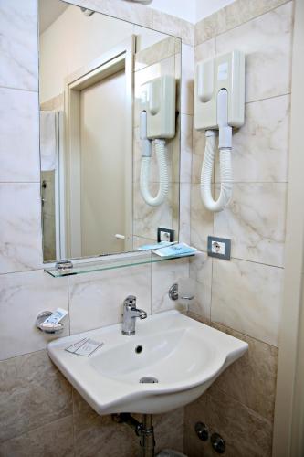 a bathroom with a sink and a mirror at Hotel Morolli in Rimini