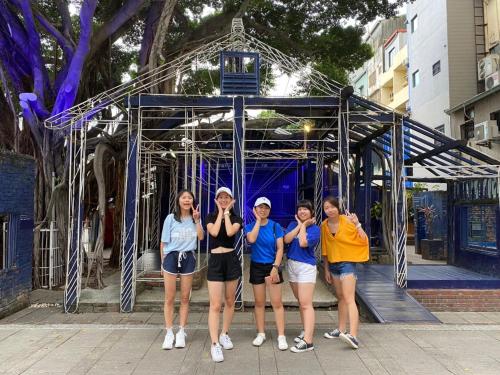 a group of girls standing in front of a gate at mydeer backpacker in Tainan