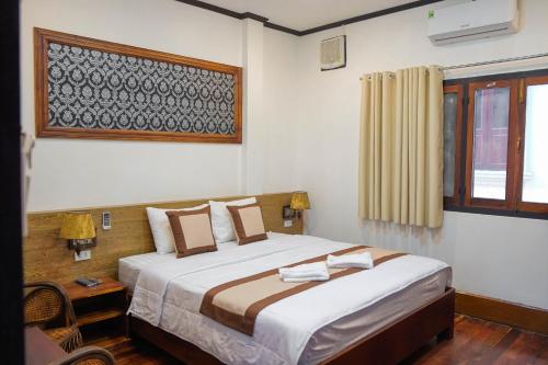 a bedroom with a large bed and a window at Duang Champa 2 Guest house in Luang Prabang