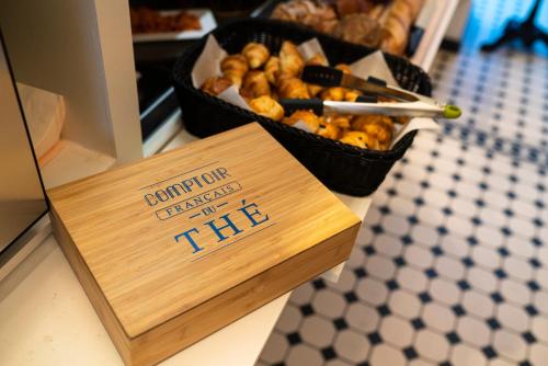 a sign on a counter with a basket of food at Hôtel Merveilleux Côté Mer in Dunkerque