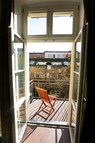a chair on a balcony with a view of a building at Garden Living - Boutique Hotel in Berlin