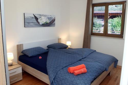 1 dormitorio con 1 cama azul y 2 almohadas de color naranja en Residence Villa Fiore Portorož, en Portorož
