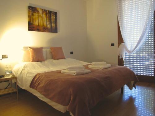 1 dormitorio con 1 cama con toallas en Vicenza City Apartments 1, en Vicenza