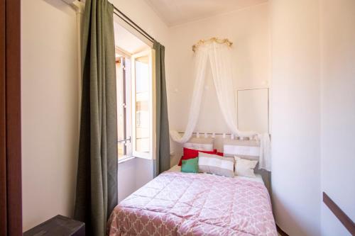 Habitación pequeña con cama y ventana en Cody's Apartment, en Roma
