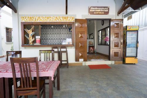 a restaurant with a table and chairs and a counter at Duang Champa 2 Guest house in Luang Prabang