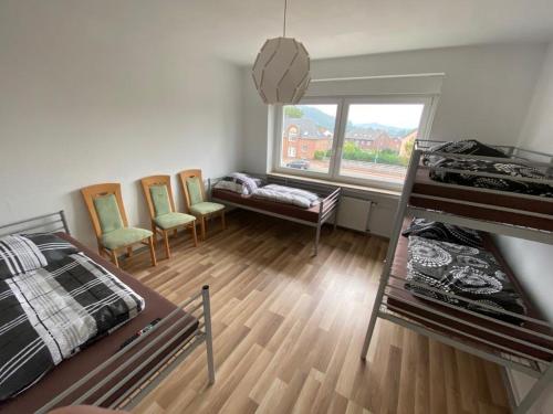 1 dormitorio con cama, sillas y ventana en Industriestraße in Belm, en Belm
