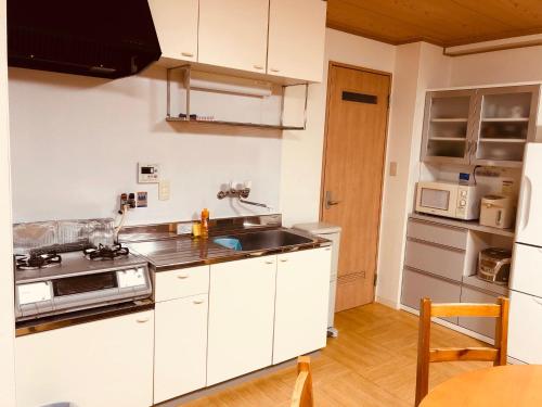a kitchen with white cabinets and a sink at Ichijyo IVY 5 persons room in Kyoto