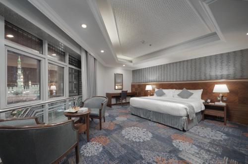 a hotel room with a bed and a desk at MADEN Hotel in Al Madinah