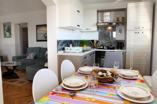 una mesa de comedor con platos y vasos en la cocina en Residence Villa Fiore Portorož, en Portorož