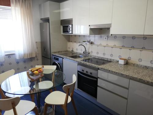 a kitchen with a table with a bowl of fruit on it at Sea View Apartment in Faro