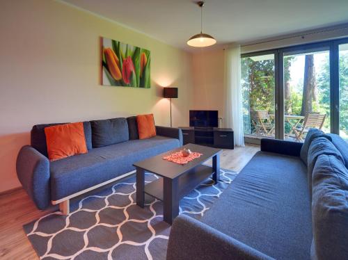 a living room with a couch and a table at Apartamenty Sun Seasons 24 - Willa Laser in Szklarska Poręba