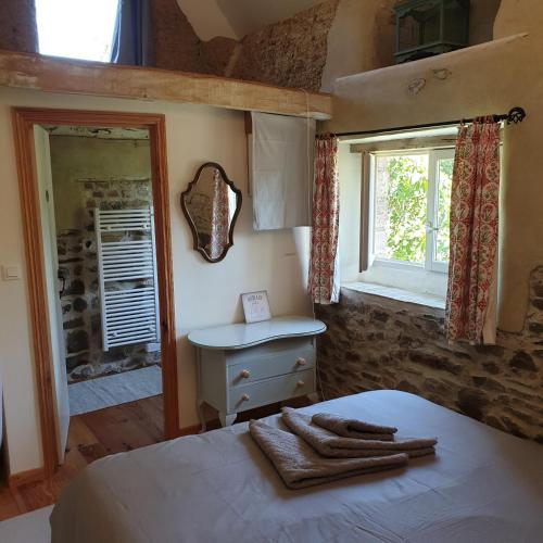 1 dormitorio con cama, lavabo y ventana en Gîte de la Founauderie, en Roncey