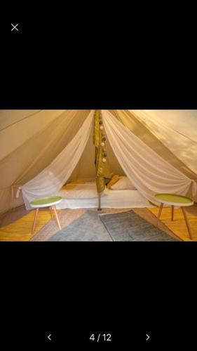 a room with a tent with a chair in it at Into the Green Glamping- Beech in Markt Nordheim