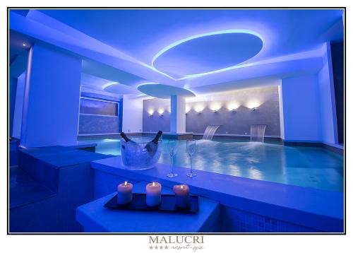 a blue room with a swimming pool and two candles at Malucri Resort in San Giovanni Rotondo