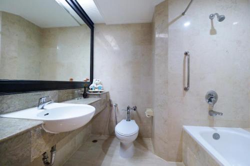 a bathroom with a sink and a toilet and a tub at Grand Arkenso Park View in Semarang