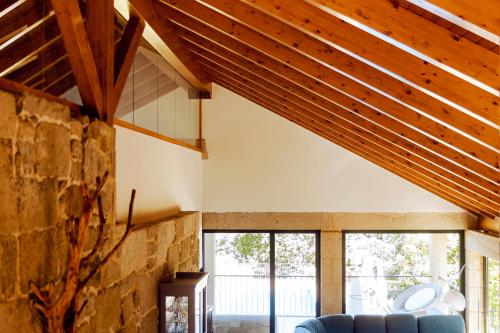 a living room with a blue couch and wooden ceiling at Bosque de Xarás, casa completa con encanto cerca de playa de Lapamán in Marín