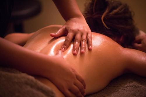 a woman getting a back massage from a therapist at Crowne Plaza Alice Springs Lasseters by IHG in Alice Springs