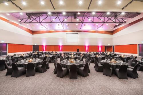 a banquet hall with tables and chairs in a room at Crowne Plaza Alice Springs Lasseters by IHG in Alice Springs